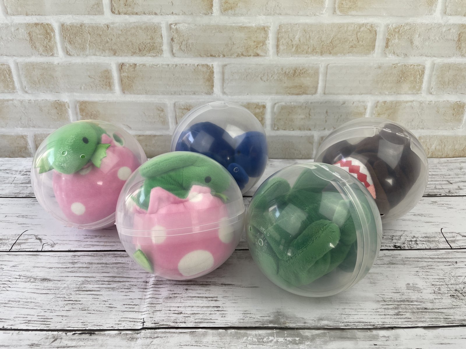 ぬいぐるみが入った透明なカプセルが5つ並ぶ、景品バリエーションの例