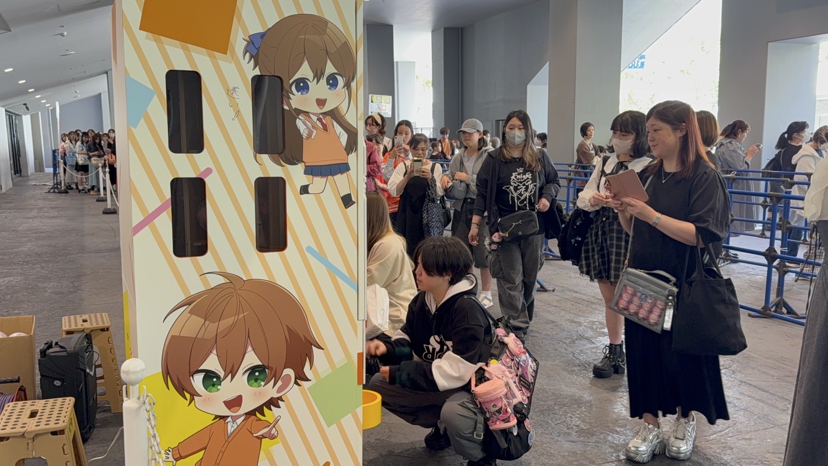 キャラクターのラッピングを施したガチャマシンの前に、順番を待つ来場者の行列